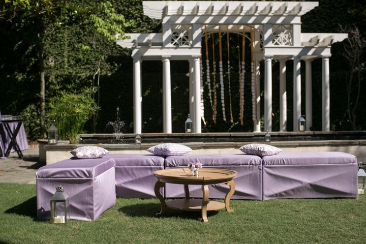 IN N’ OUT: The elegance of the house’s interior easily transferred to the garden with lavender sateen bench ottomans, antique furniture, and escort-card laden streamers swinging from the palatial white arbor.