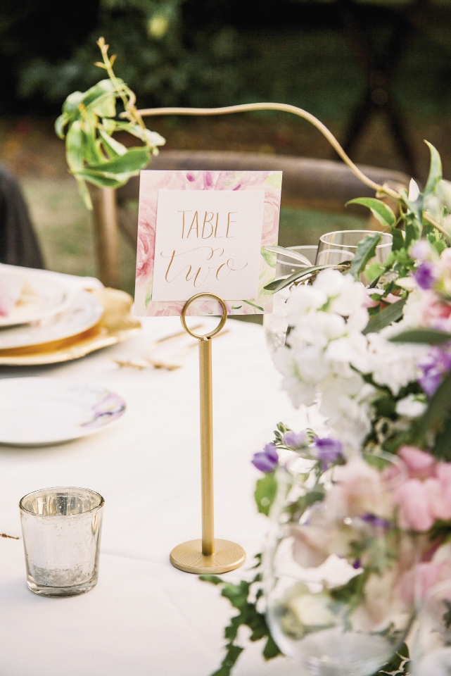 Table numbers riffed off the invitation suite while mercury glass votives added tabletop luster even before dark fell.