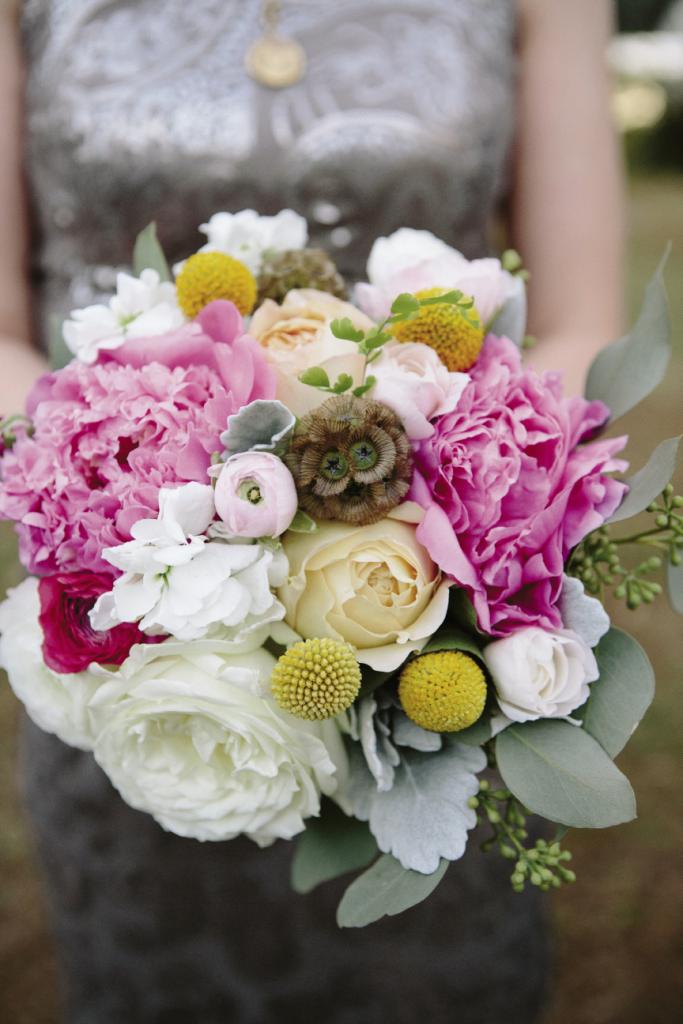 COPY CAT: Embedded among roses and ranunculus, earthy scabiosa in bridesmaids’ bouquets echoed the groomsmen’s boutonnieres.
