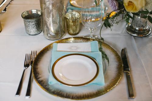 IN THE THEME: The bride dubbed the evening’s main hue ‘Antique Turquoise.’ Sara Hosch of Southern Protocol incorporated the color throughout the design, like with these napkins paired with the gold-rimmed reception china.