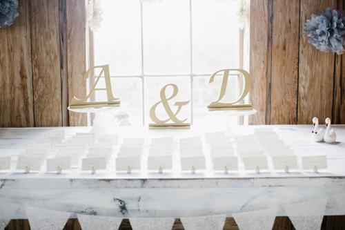 CRAFT CORNER: Lift a simple escort card display with natural wooden letters—found in any craft store—in the couple’s monogram.