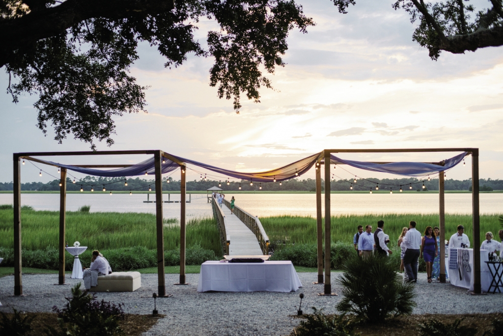 SHINE ON: “Having such an amazing place to start with made decorating easy,” says the bride. Lindsey erected a simple frame and topped with gauzy navy fabric, which accented rather than hid the setting.