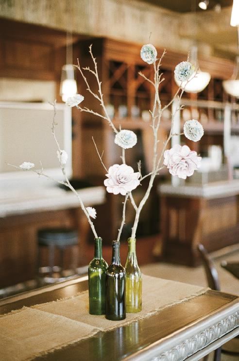 BOTTLED UP: Bottles—with the bases sliced off—became vases. To make paper flowers, search www.WeddingChicks.com for steps.