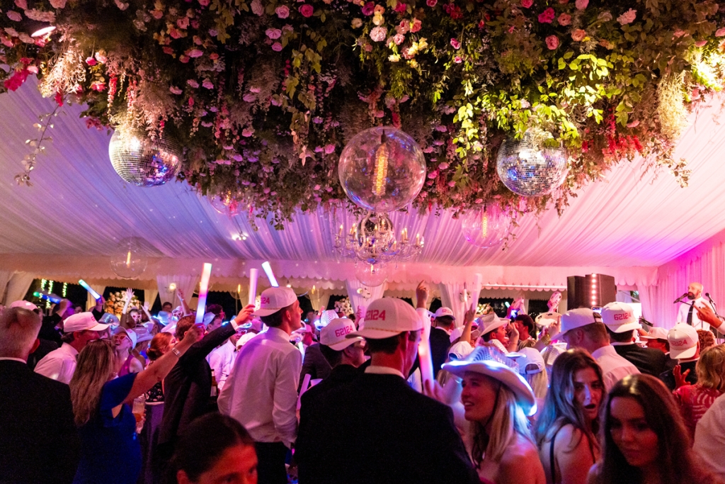 Beneath a dramatic ceiling installation of bright blooms and disco balls, the reception transformed into a dance party for the ages.