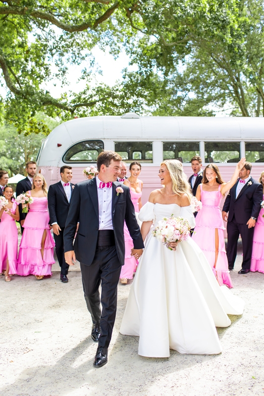 Maddie Flemming and Austin Murray said “yes” to a bold pink wedding punctuated with bright bridesmaids’ gowns, vibrant feather bow ties, and a blush-colored bus from Lowcountry Valet.