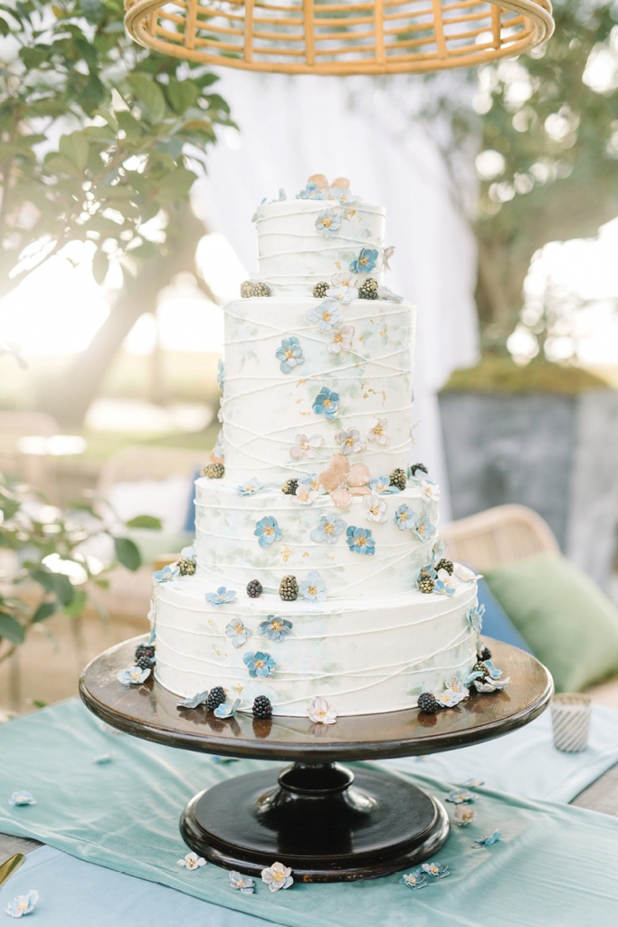 The couple’s four-tiered confection by Jim Smeal was comprised of layers of lemon, chocolate raspberry, and caramel cake and adorned with sugar-spun flowers and gold-specked blackberries.