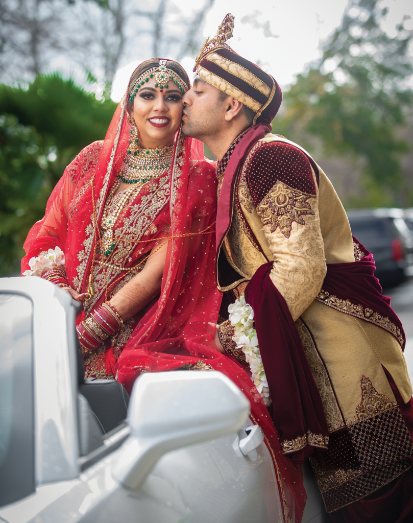 Donning conventional  crimson-colored Indian wedding attire, Swati and Brijesh Patel exchanged vows underneath a cascading floral mandap, or canopy