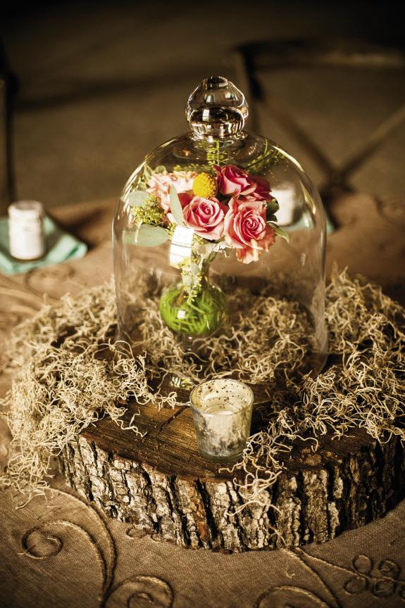 THE BELL JAR: Centerpieces brought the outdoors in with slabs of wood, Spanish moss, and pretty little bouquets magnified by glass cloches.