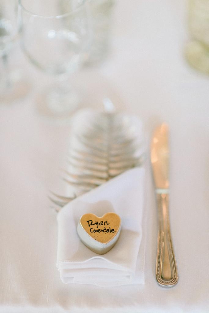 Concrete heart place cards (made with silicone ice cube trays) and gold-painted fern fronds greeted guests. Photograph by Sean Money + Elizabeth Fay.