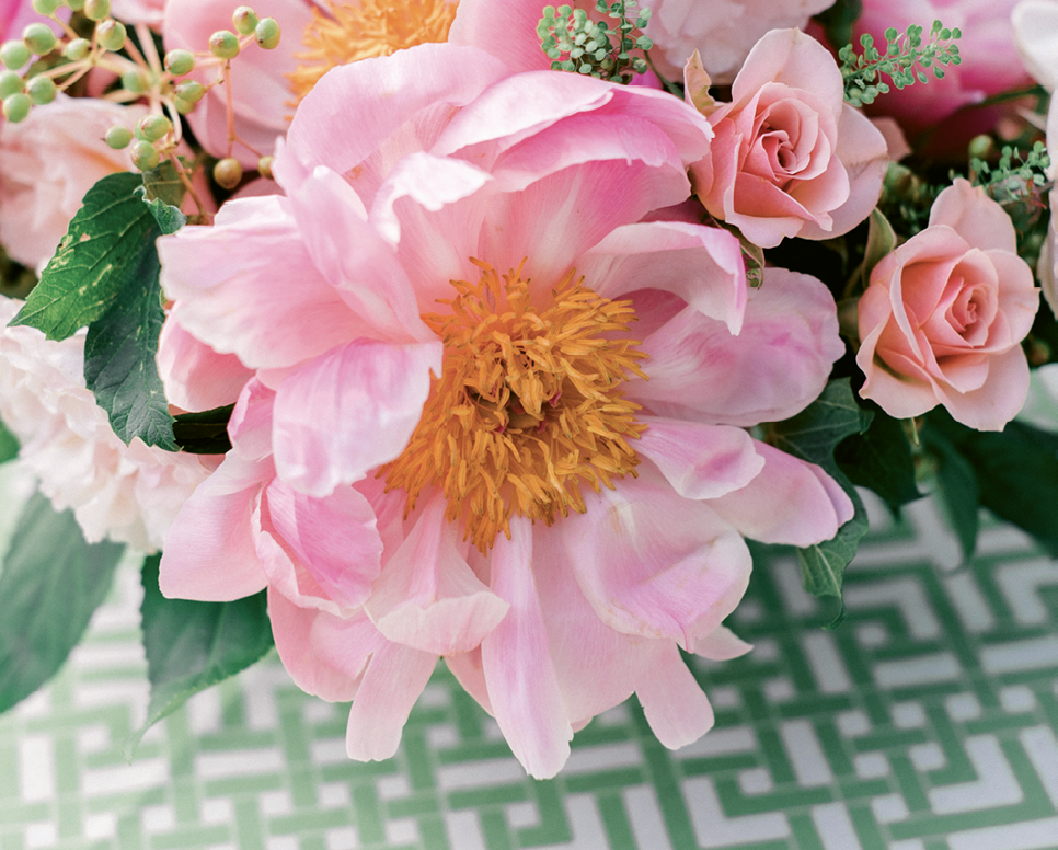 Floral arrangements by Gathering Events paired fluffy pink blooms with tropical leaves and green berries for a look that was both lush and preppy.