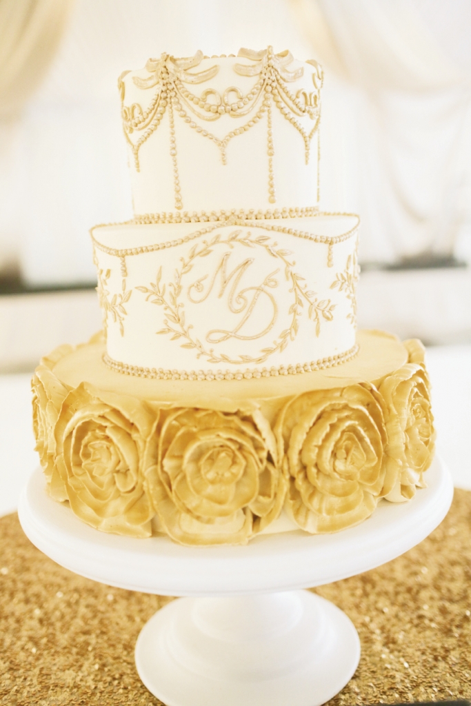 SIMPLY STUNNING:  For Meredith Sever and Dan Tanton’s December 2013 fête, Wedding Cakes by Jim Smeal fused patterns from the stationery suite and the bride’s gown with gold—the reception’s star hue—for a  brilliant confection.