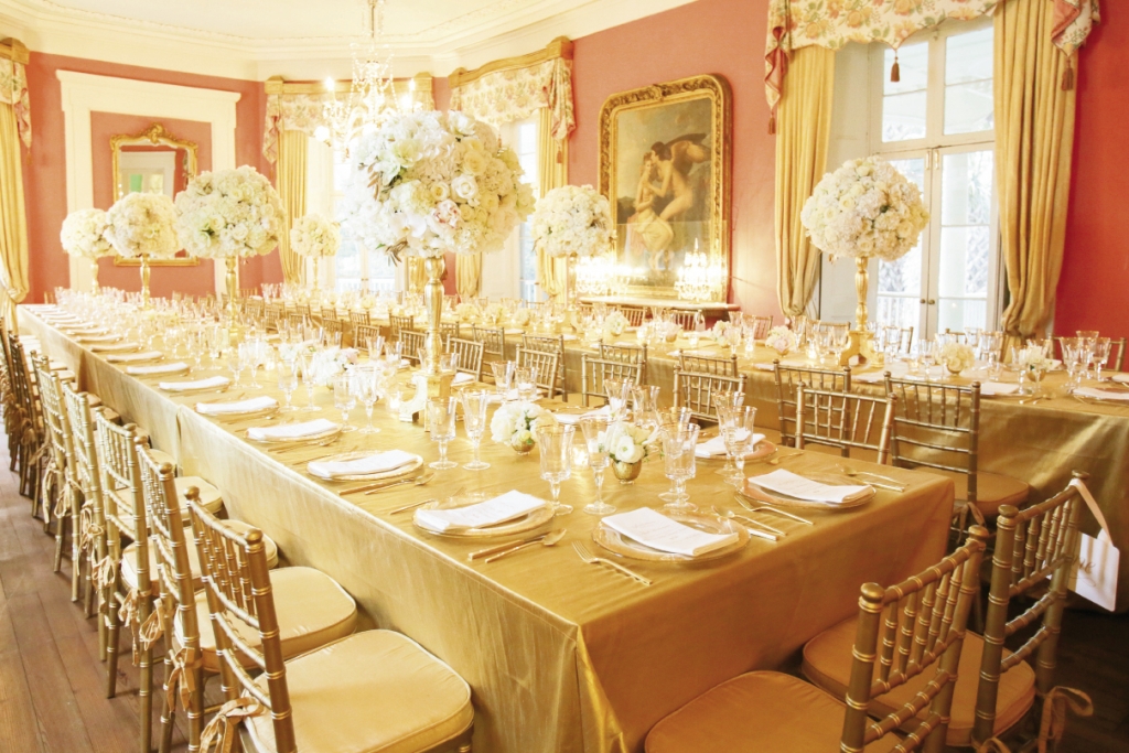 “When you are working with a strong color like gold,” says bride (and planner) Meredith, “do a mock-up in the space with a set of the tablescape elements, linens, and chairs to see how the whole picture works together.” Here, golden tablecloths and chiavari chairs are a natural extension of the room’s gilded frames. Image by The Connellys.