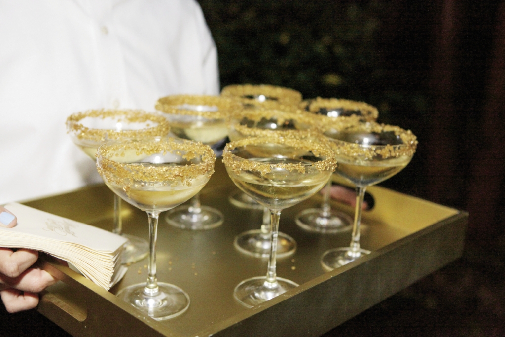 Rim coupe glasses with gold sugar for thematic (and edible) trimming. Image by The Connellys.