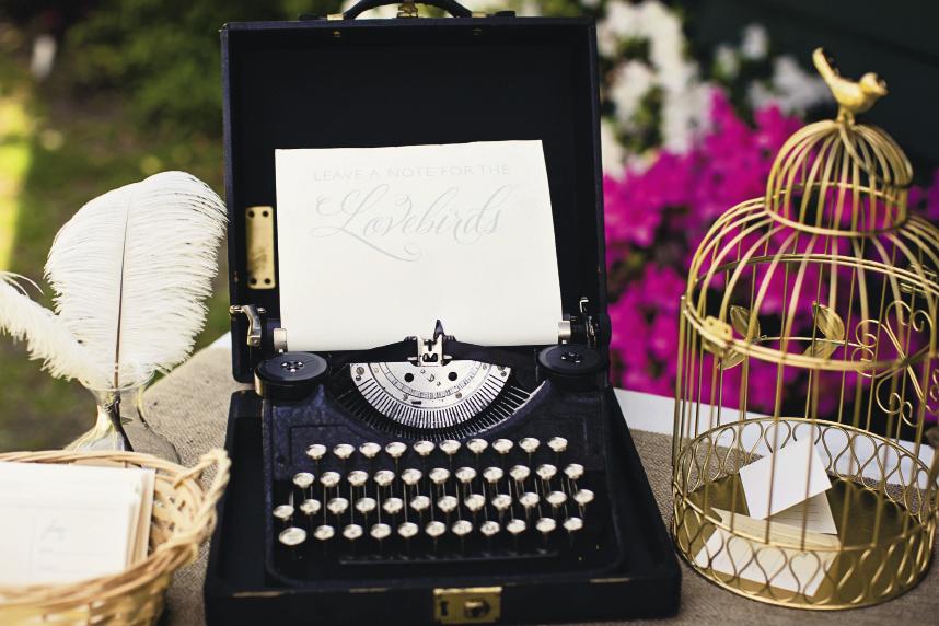 THINK OUTSIDE THE BOX: The bride found wire birdcages at Michaels for $4 each. To suit the reception&#039;s color scheme, she spray-painted them gold. The typewriter was an antique rustled up from her parents&#039; garage.