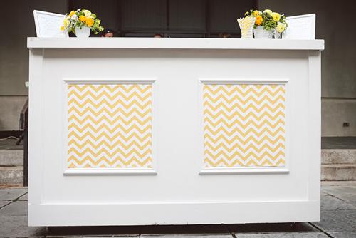 SPICE THINGS UP: Jacqueline also used spare yellow chevron fabric to panel the reception bar, transforming it from a standard white to a colorful custom piece.