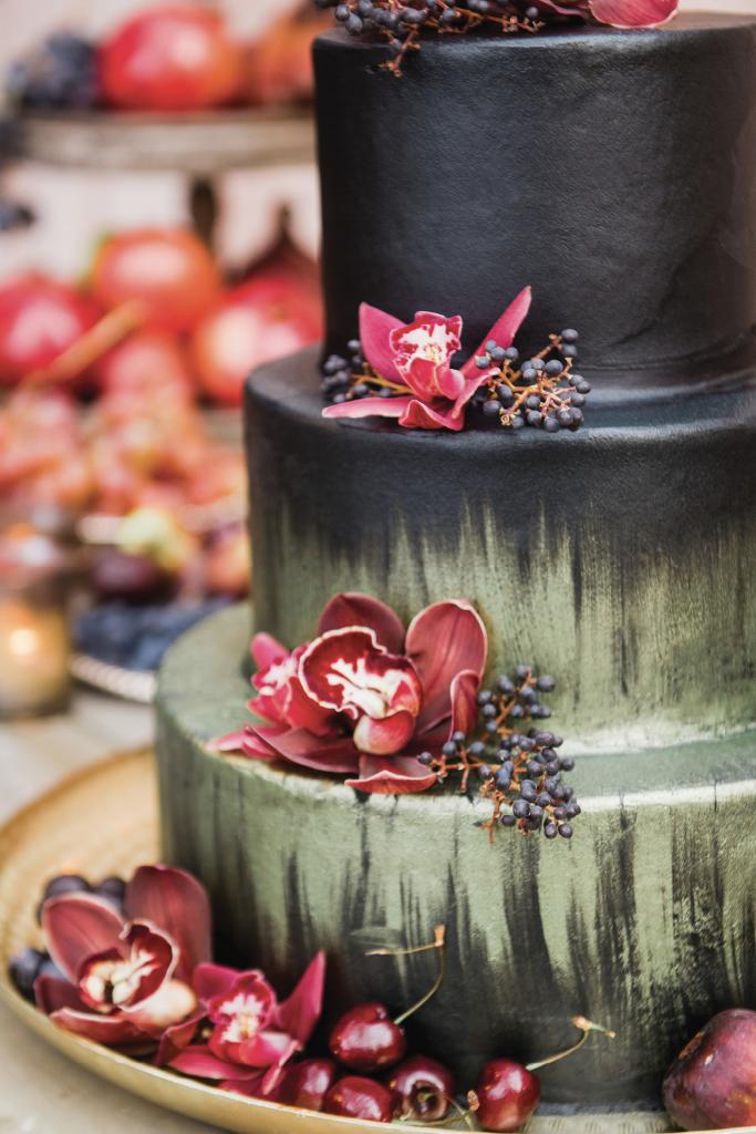 The red velvet cake was hand-painted and topped with fresh fruit and orchids, while tables were covered in lush florals and dripping candles.