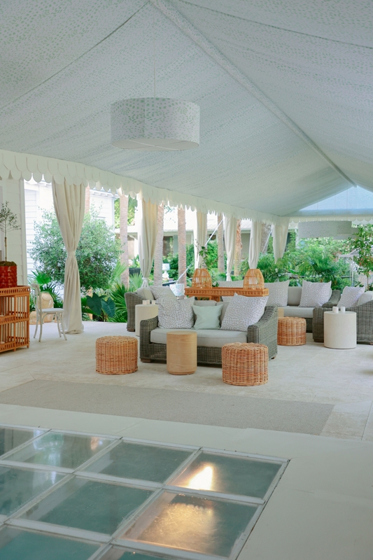 Under a luxuriously draped tent, fabric-wrapped light fixtures, woven outdoor furniture, and a custom dance floor atop the pool gave an Amalfi coast elegance to the reception.