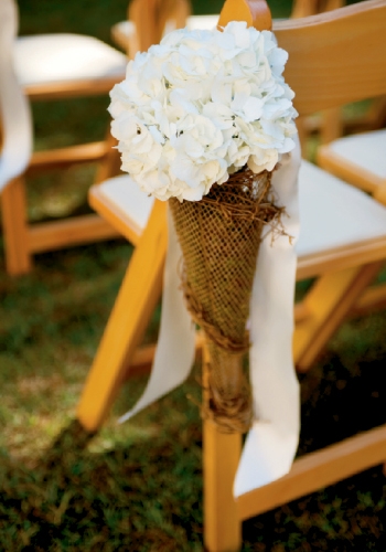 Aisle markers of simple white hydrangea wrapped in burlap complemented the scenery.