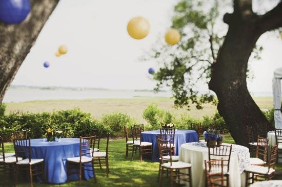 SMART CHOICE: With its sweeping trees and serene view of the marsh, the plantation’s surroundings drove the light-touch approach to décor. Here, Stacey placed understated centerpieces atop small reception tables and hung Chinese lanterns overhead.