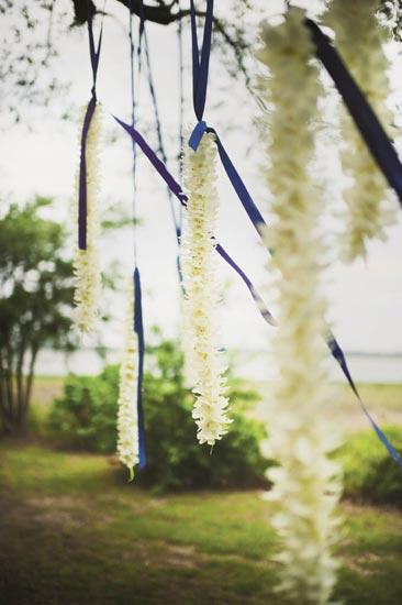 HANGING OUT: Wedding designer Stacey Fraunfelter of Red Letter Events hung garlands of white dendrobium from blue ribbons looped around tree branches.