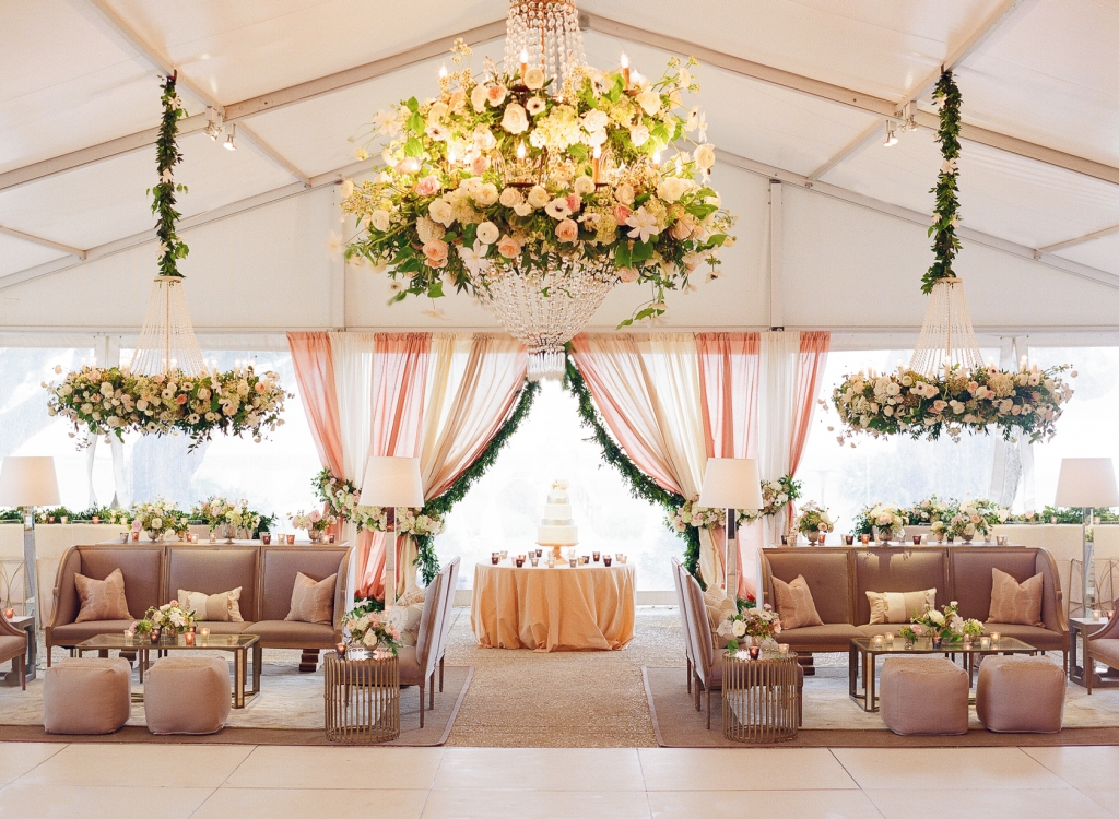 Showstopping floral chandeliers drew eyes upward while a mix of traditional and modern furnishings filled the tent below. “Meggie is super hip and wanted a youthful vibe, so we layered in clean touches, like Lucite-and-gold barstools,” says Calder. &lt;i&gt;Image by Lucy Cuneo Photography&lt;/i&gt;