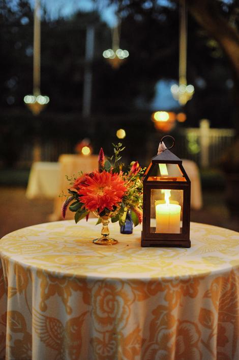 FIERY NIGHT: As the sun set, candlelight brightened the reception tables while dangling outdoor chandeliers and café lights filled the garden with a romantic glow.